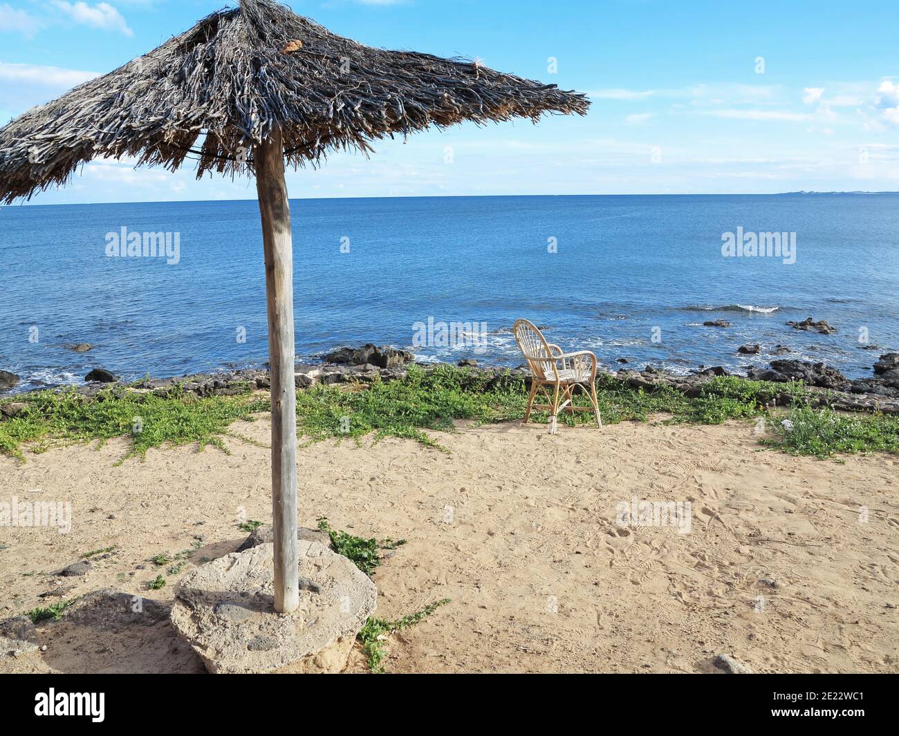 An empty chair looks inviting, offering a place in the sun with a sea view Stock Photo