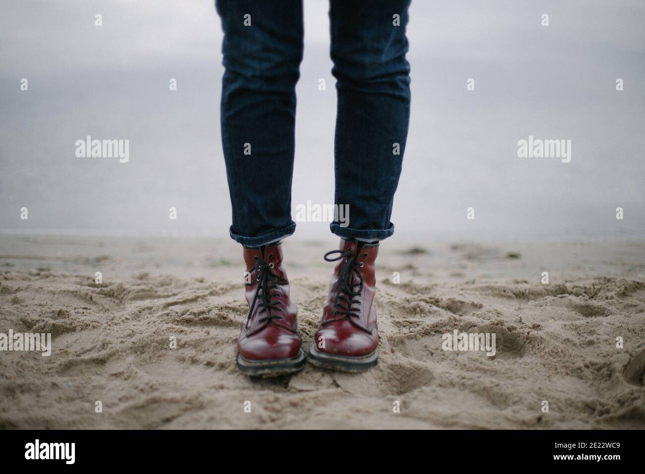 Red dirty hipster boots in the sands with dark blue jeans seashore Stock  Photo - Alamy