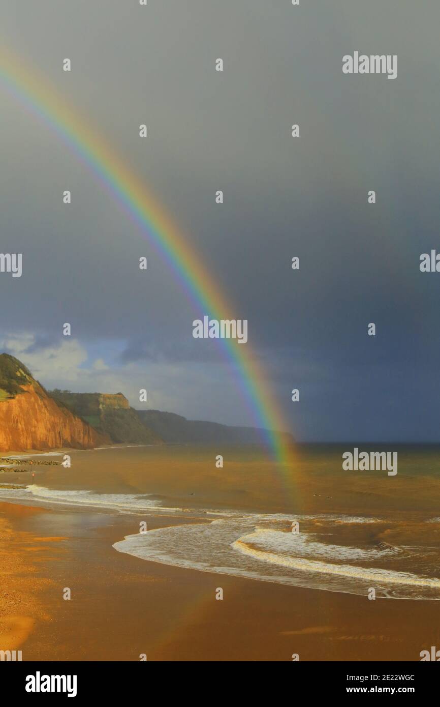 Rainbow above sandy beach in Sidmouth, Devon on the Jurassic Coast Stock Photo