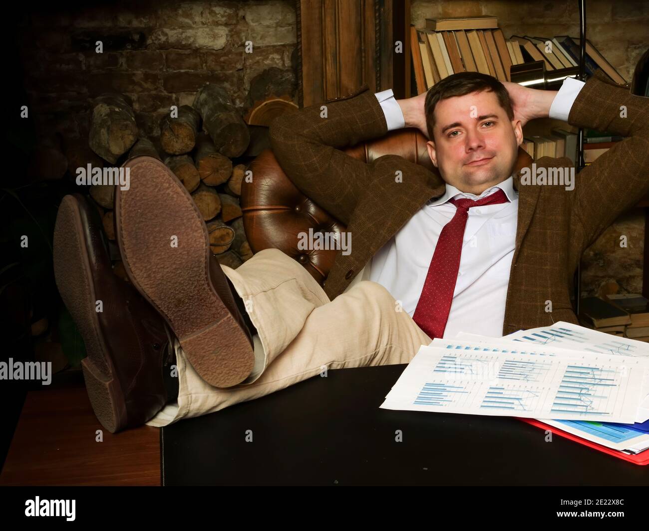 Happy relaxed businessman with feet on the table. Stock Photo