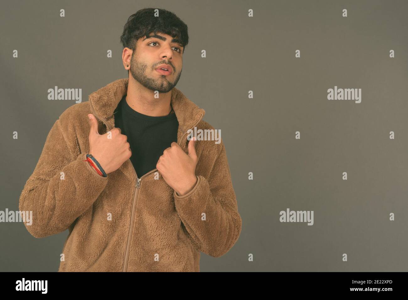 Young handsome Indian man against gray background Stock Photo