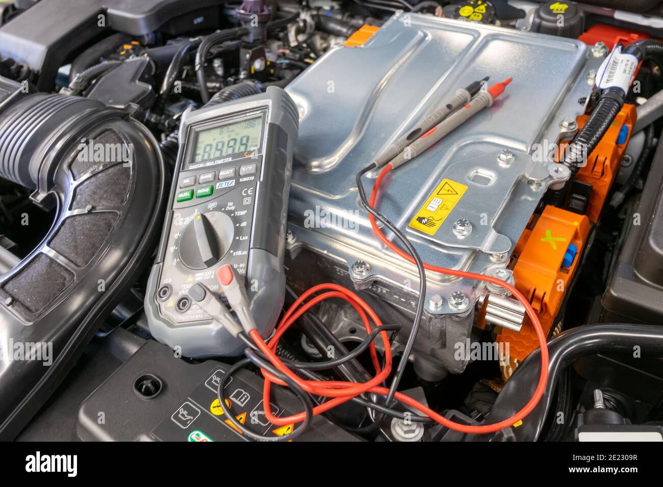 multimeter ready for use in the engine compartment of a Hybrid car