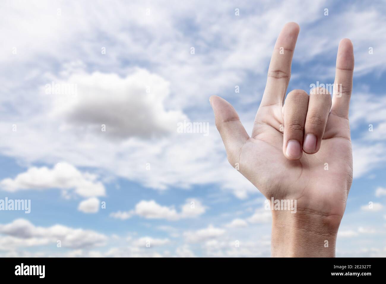 love hand sign on blue sky background with cloudy. I love you concept. Stock Photo