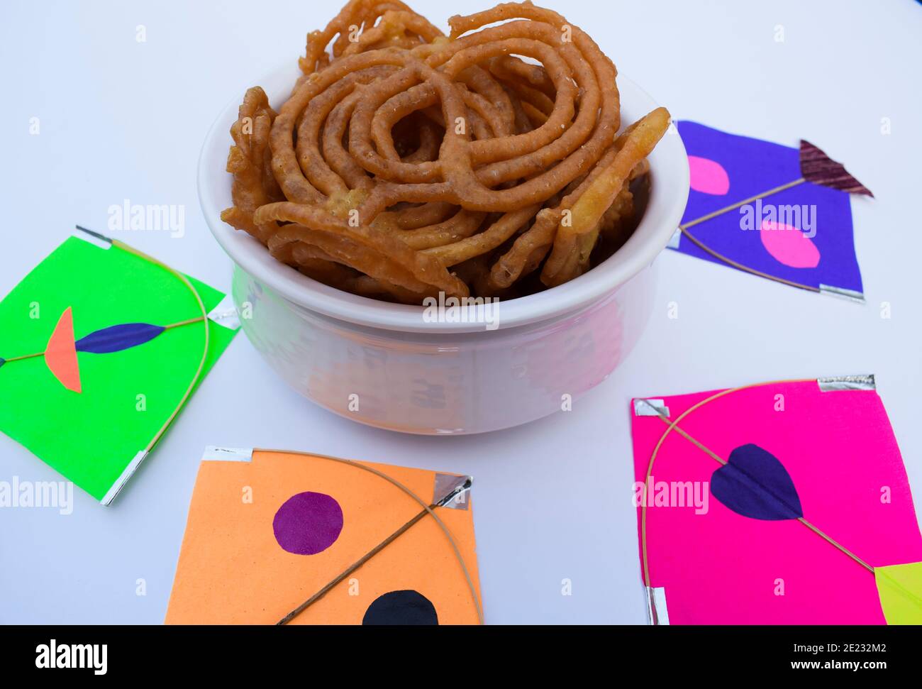 Popular sweet dish Jalebi searved during Indian kite festival of Uttarayan or makar sankranti in gujarat. Decorated with multicolor colorful kites. Sw Stock Photo