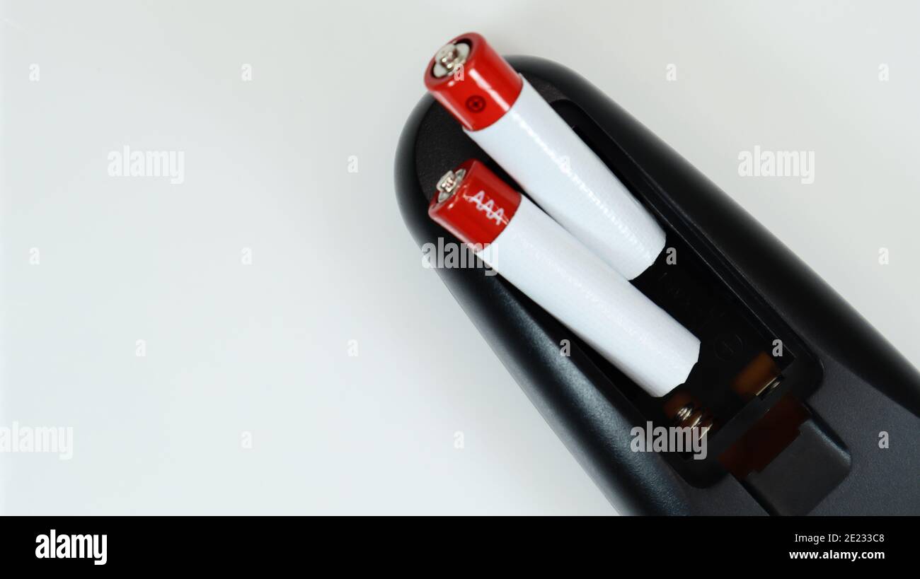Black TV remote control with AAA alkaline batteries on a white