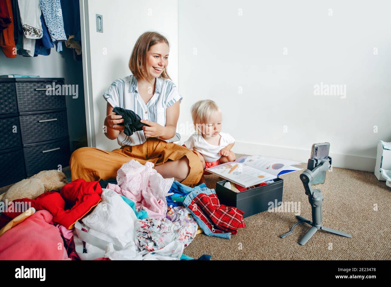 Young mother blogger doing video live stream for social media while sorting  clothes at home. Video call chat with friends and family on smartphone  Stock Photo - Alamy