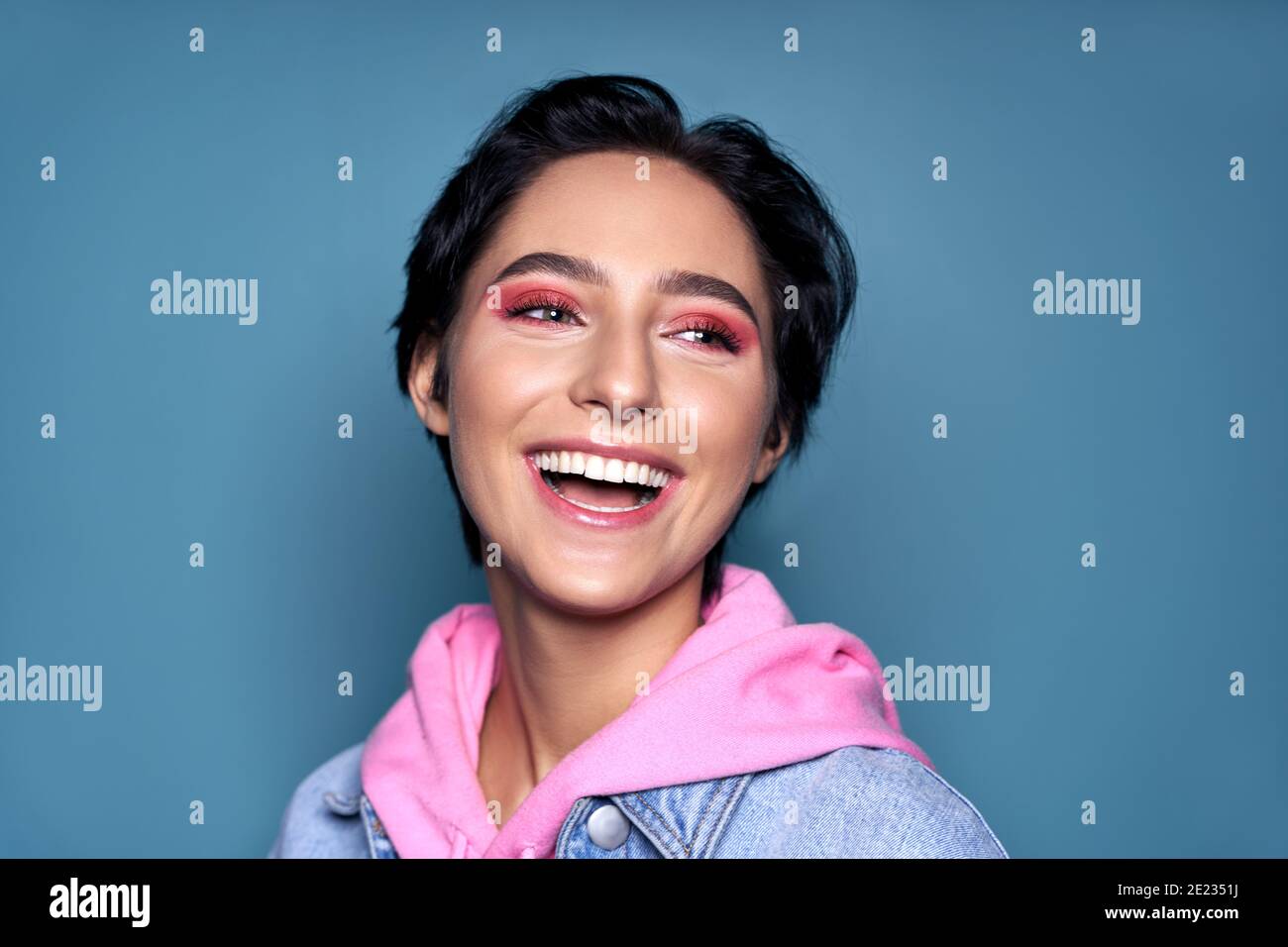 Happy teen girl face with dental healthy smile isolated on blue background Stock Photo