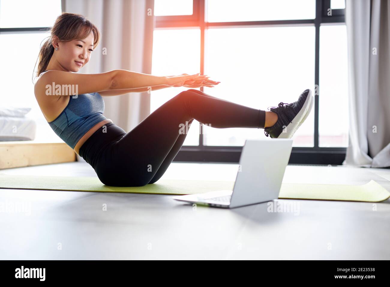 asian woman doing pelvic lift abdominal exercise on the floor in