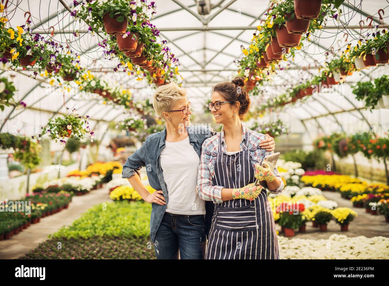 Two beautiful successful florists standing proud in their greenhouse