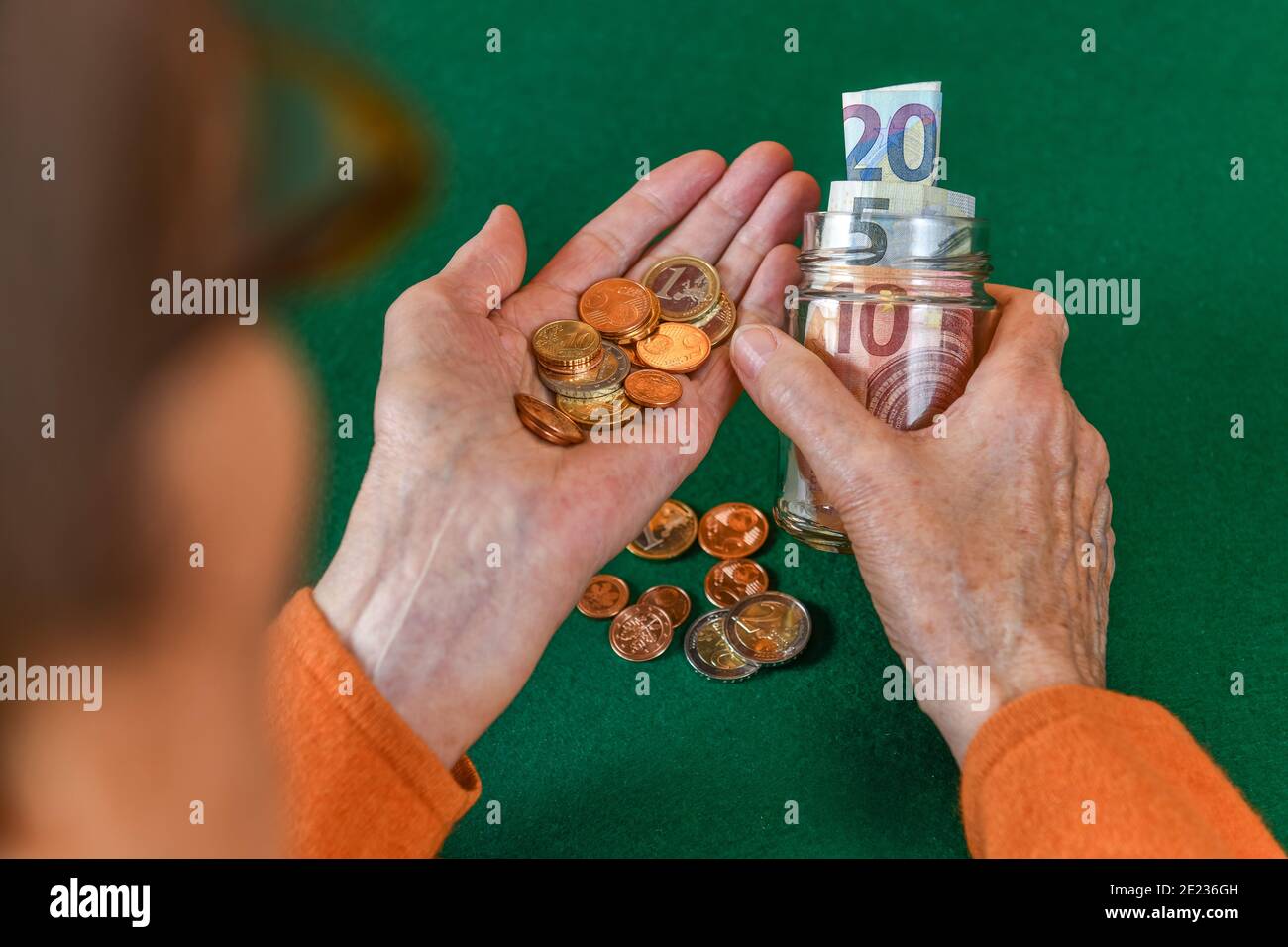Symbolfoto, Rente, Seniorin, Haende, Geld, Sparbuechse Stock Photo