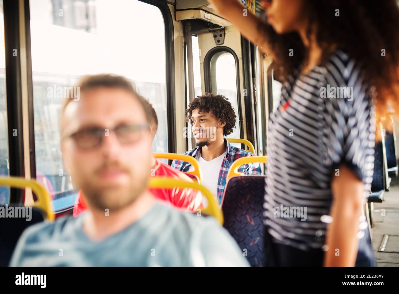 Charming Afro-American man is looking through the bus window and smiling. Stock Photo