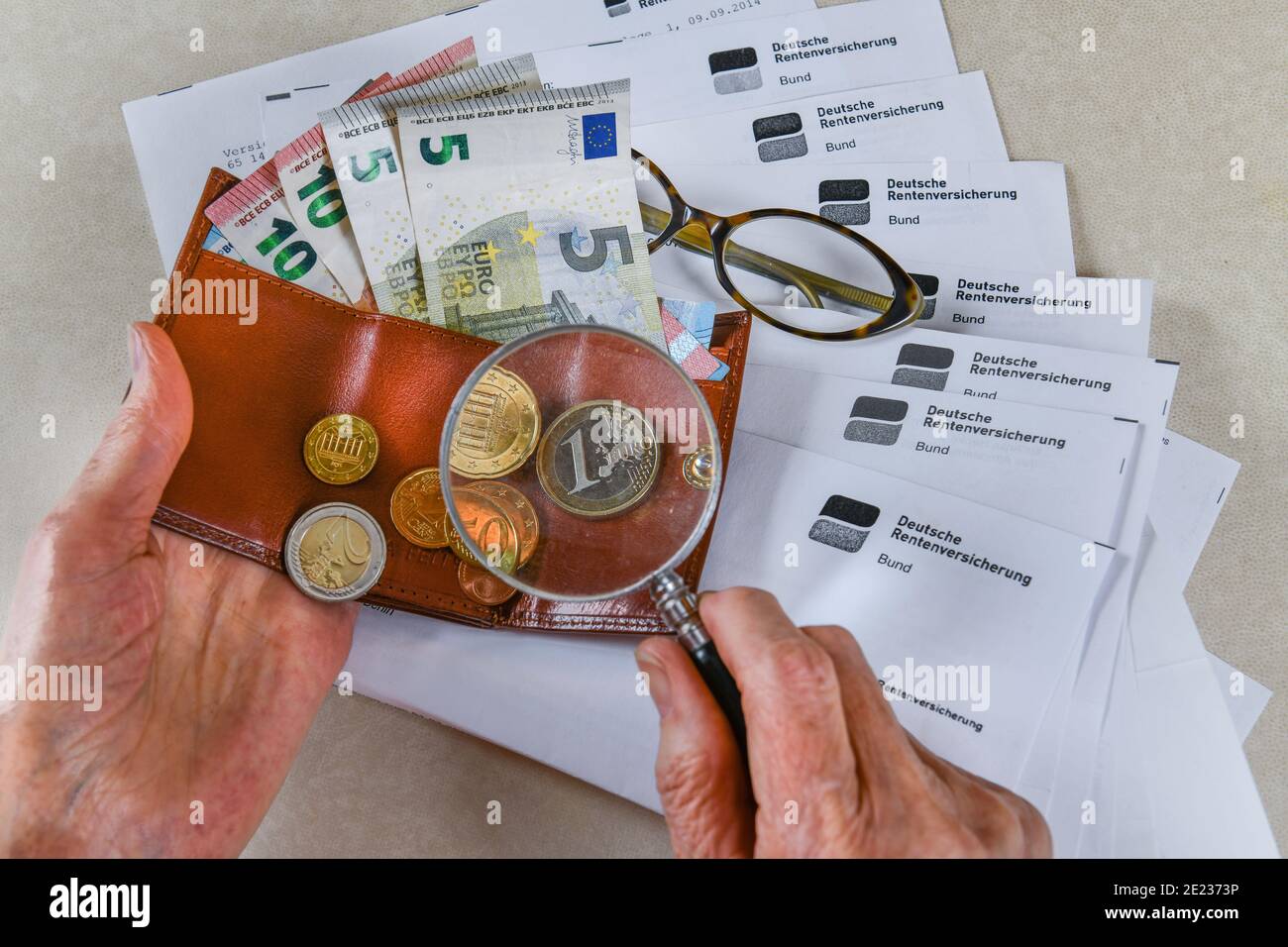 Symbolfoto, Rente, Seniorin, Haende, Geld, Portemonnaie, Lupe, Rentenbescheid Stock Photo