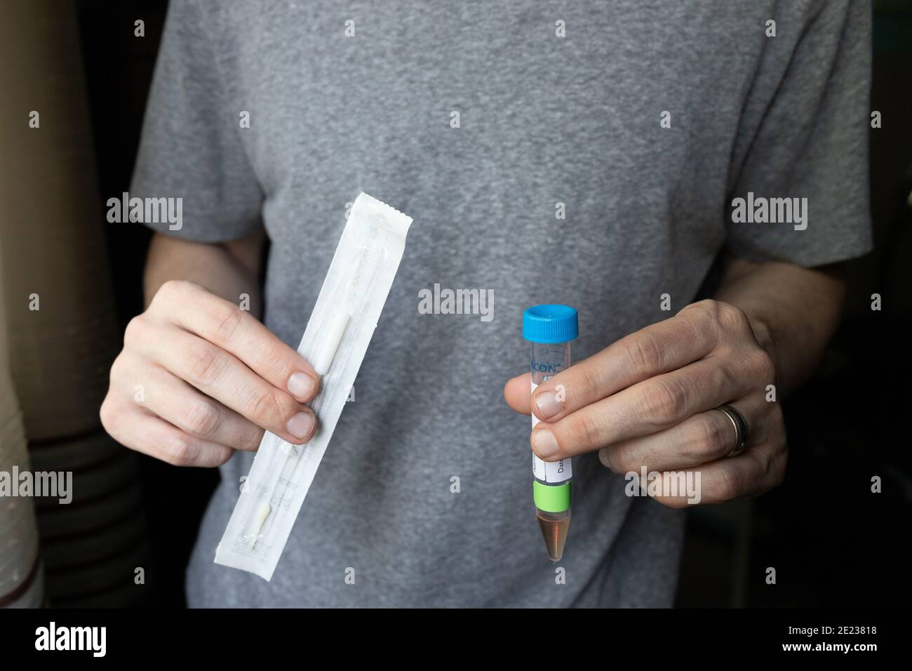 Man Holding Nasal Swab and Test Tube to Take a COVID-19 At-Home Test Stock Photo