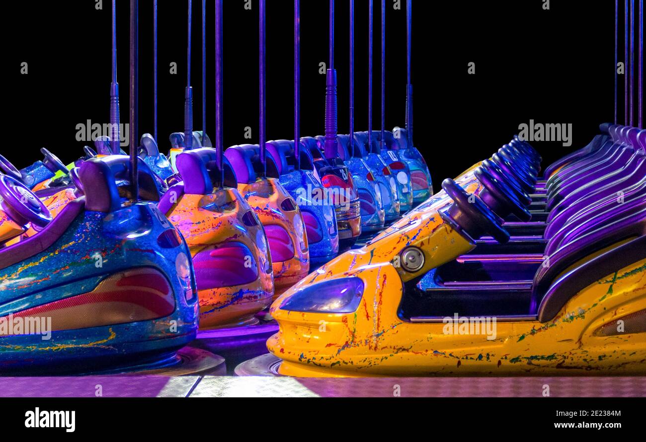 rowed colorful bumper cars in front of black back Stock Photo
