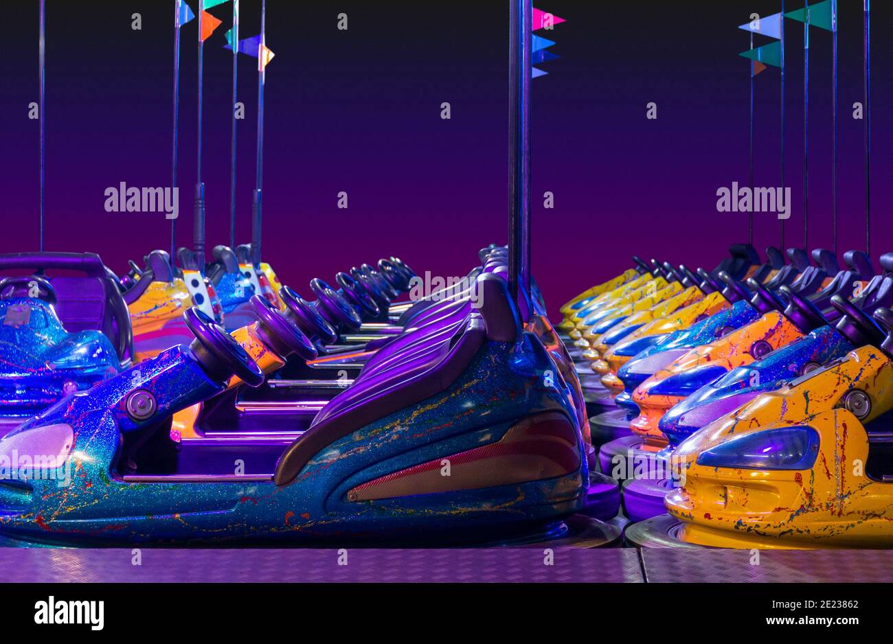 rowed colorful bumper cars in front of gradient colored back Stock Photo