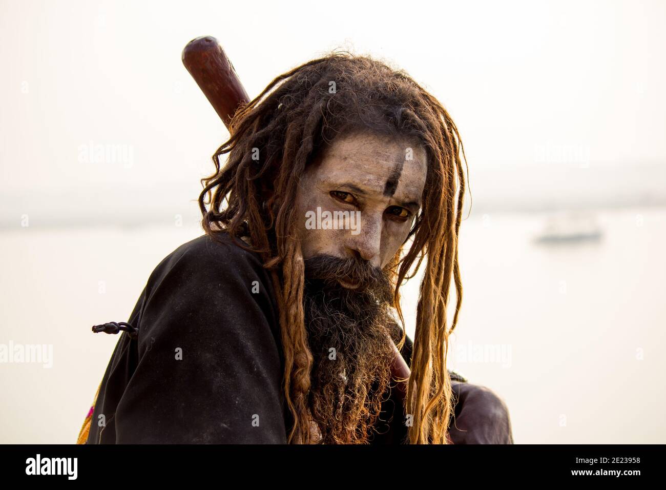 Varanasi, India - November 01, 2016: Portrait of a male hindu sadhu baba aghori pilgrim with dreadlock against ganges river Stock Photo