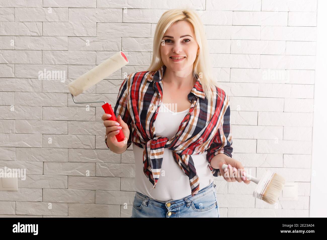 Beautiful young woman painting wall in room Stock Photo - Alamy
