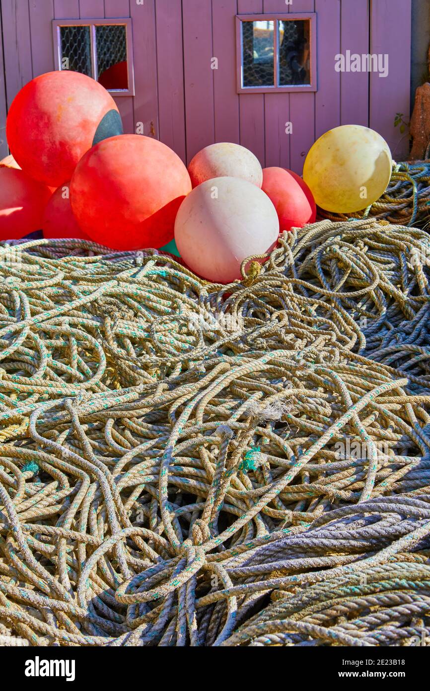 Image of old fishing ropes with float bouys in front of a timber ...