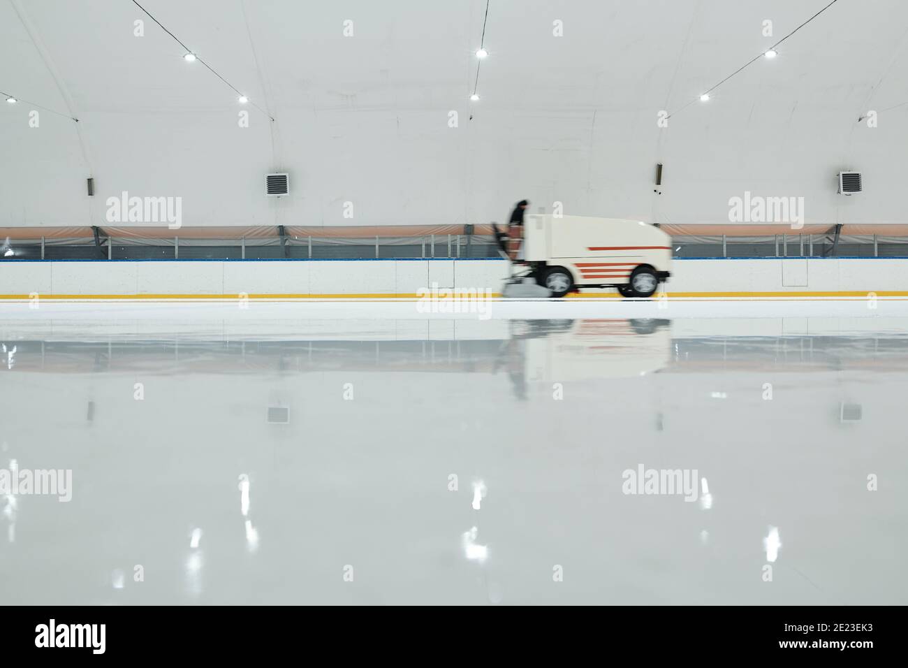 White truck or ice flattening machine moving along icerink while preparing it for playing