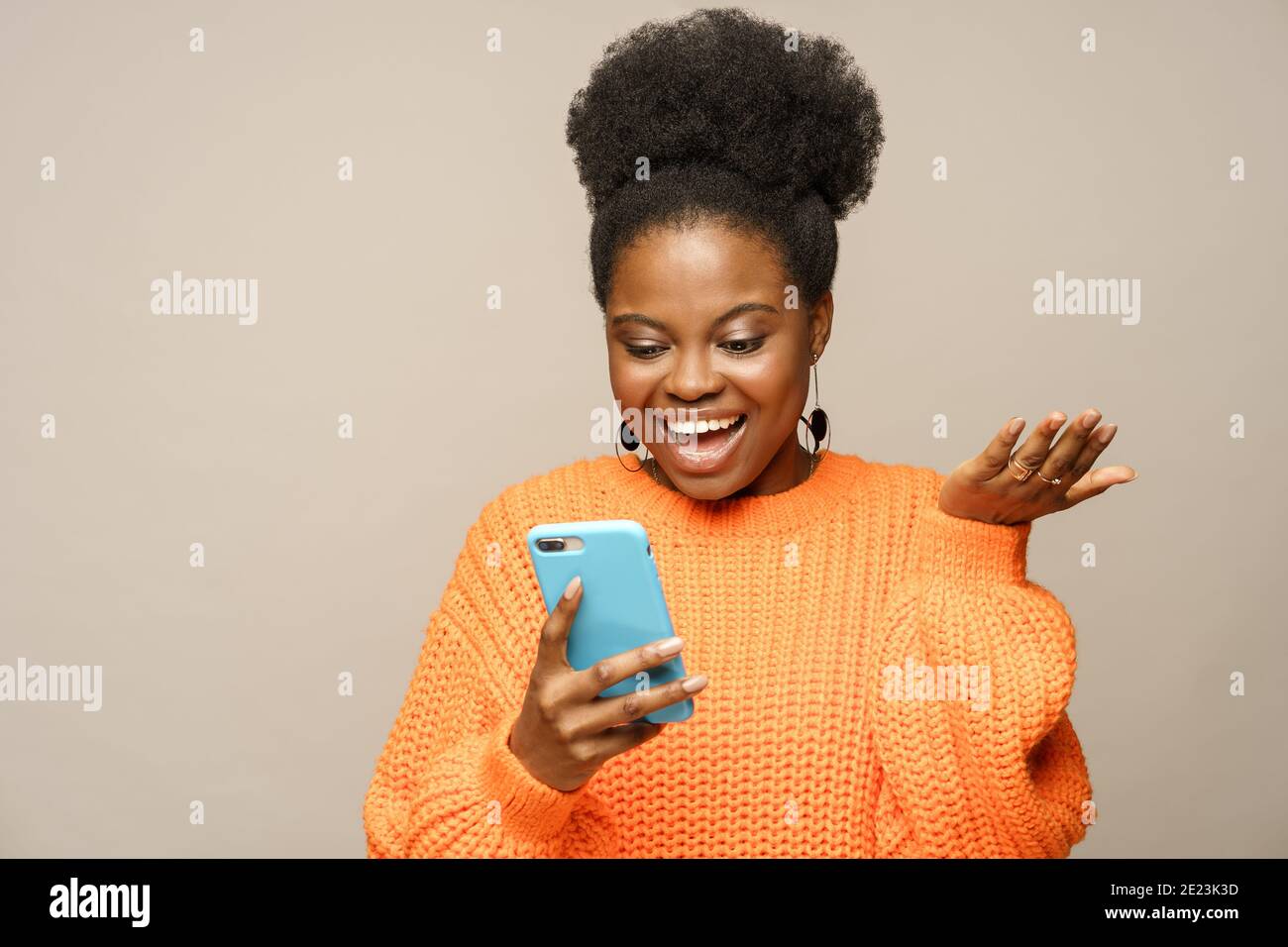 Afro millennial woman laughing, reading message from boyfriend chatting in social media on phone Stock Photo