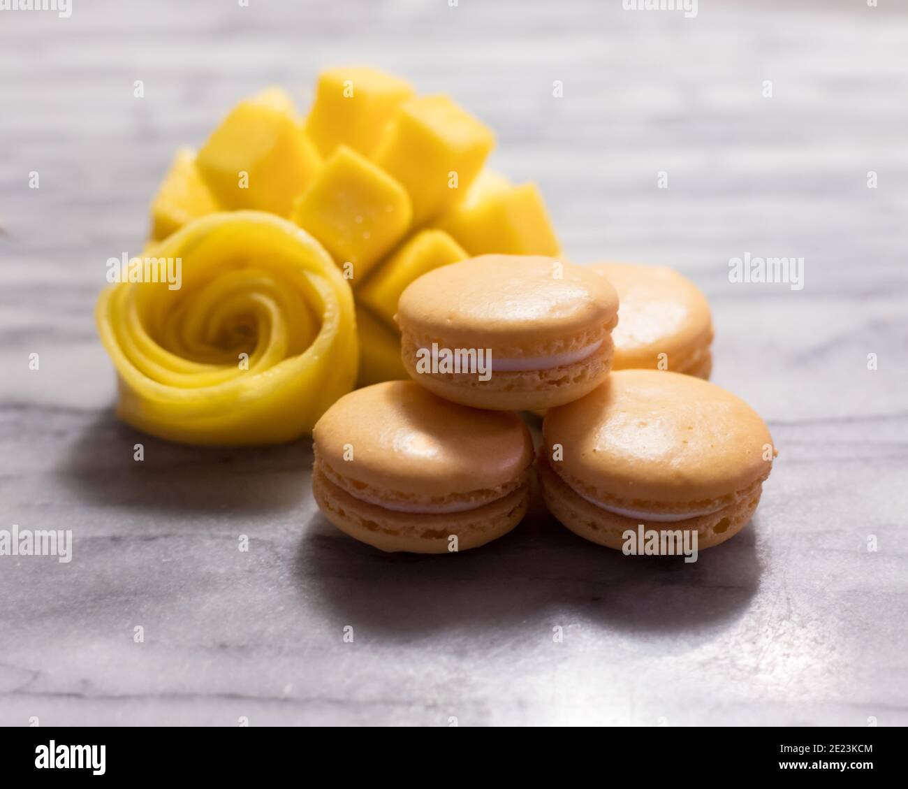 Mango Macarons with Mango Rose on White Marble Stock Photo
