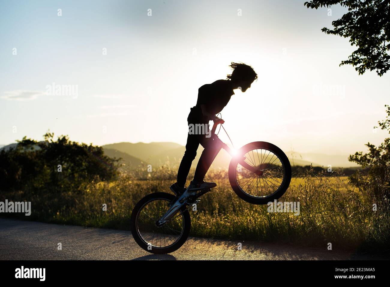 persona saltando con la bicicleta delante del sol Stock Photo