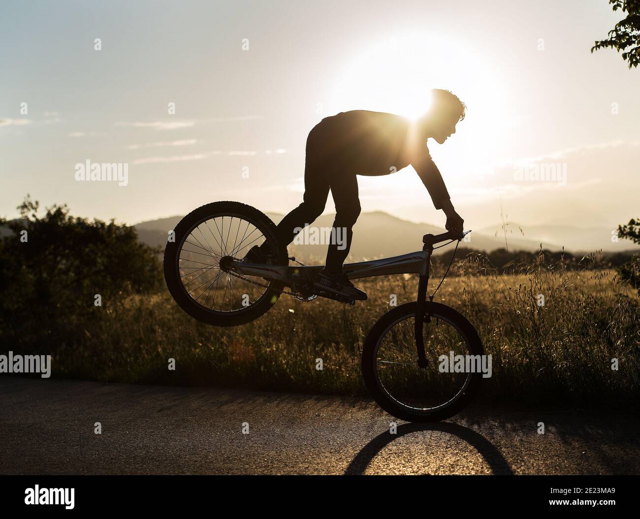 persona saltando con la bicicleta a traves del sol Stock Photo