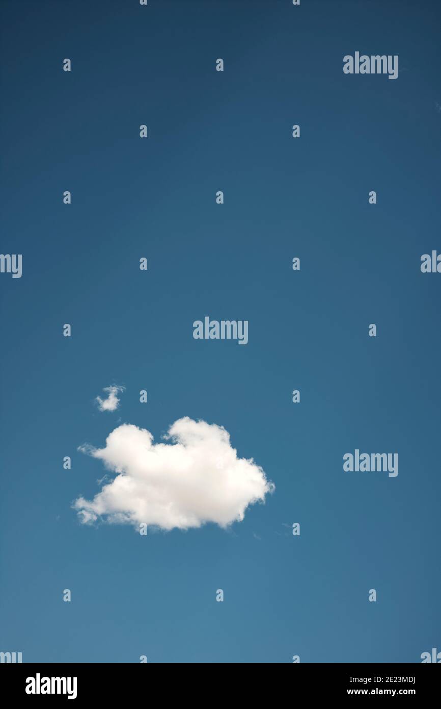 From below of white fluffy cumulus cloud floating in clear blue sky on ...