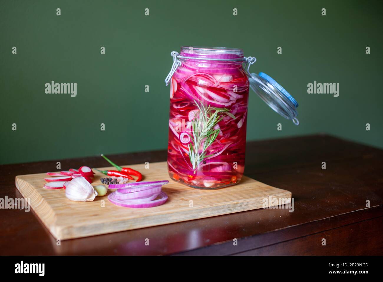 Homemade sweet and spicy pickled red onions sliced in a large glass jar