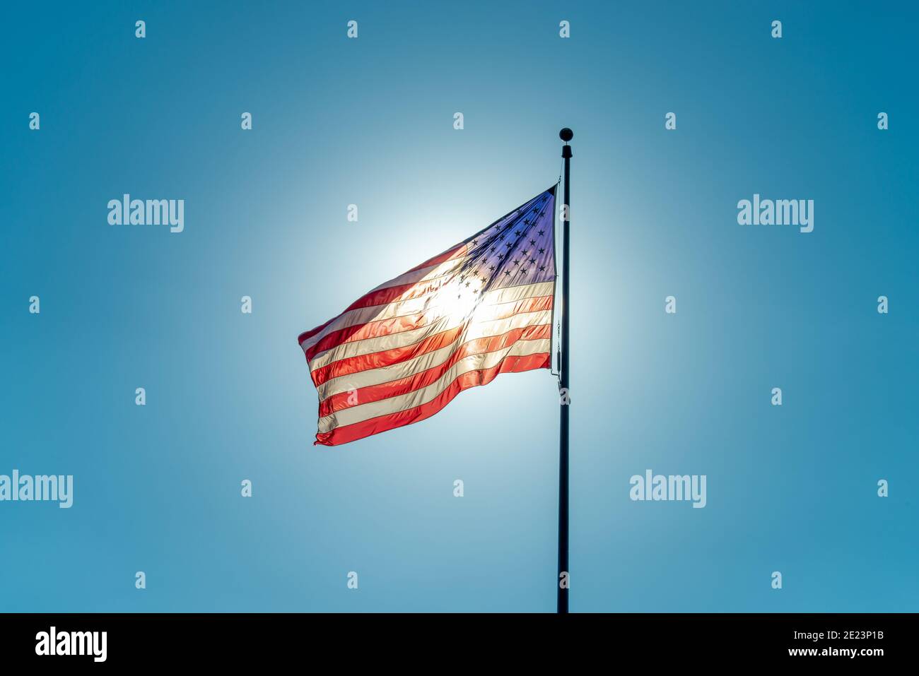 American flag against a clear blue sky lit from behind by the sun Stock ...