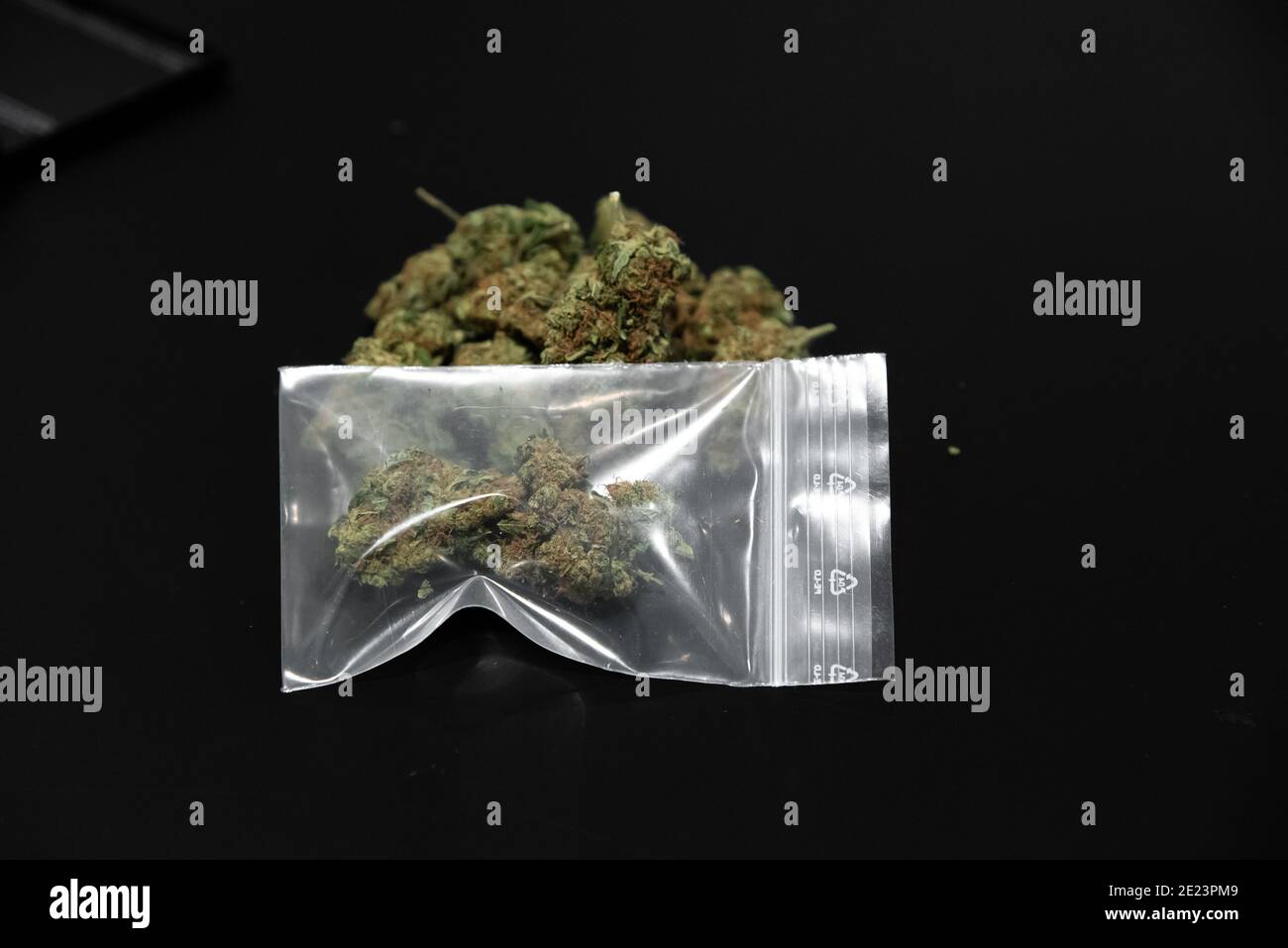 Closeup of Cannabis buds in a plastic bag on the table with a blurred background Stock Photo