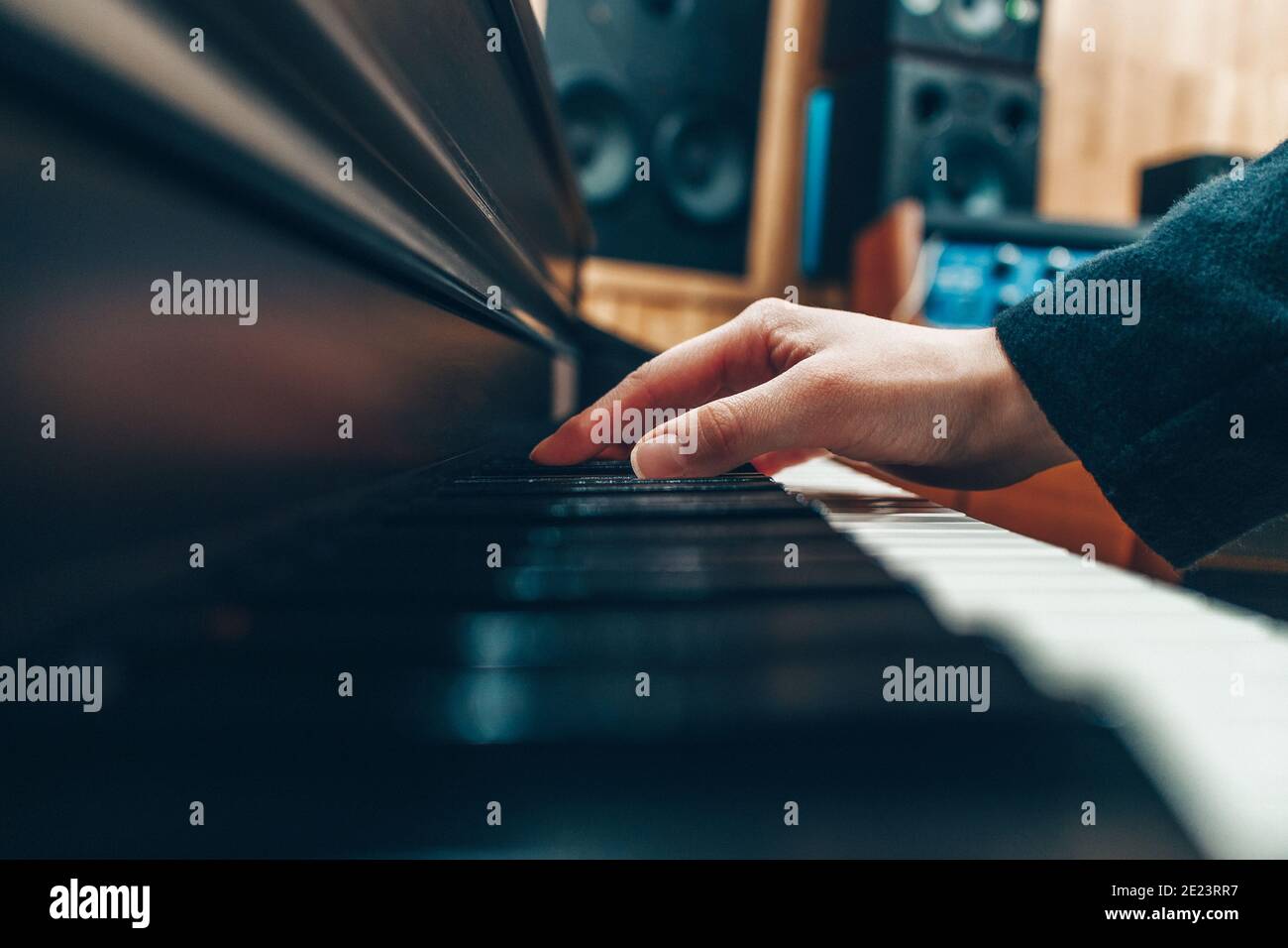 Female hand on the keys of a piano in a recording studio. Record a ...