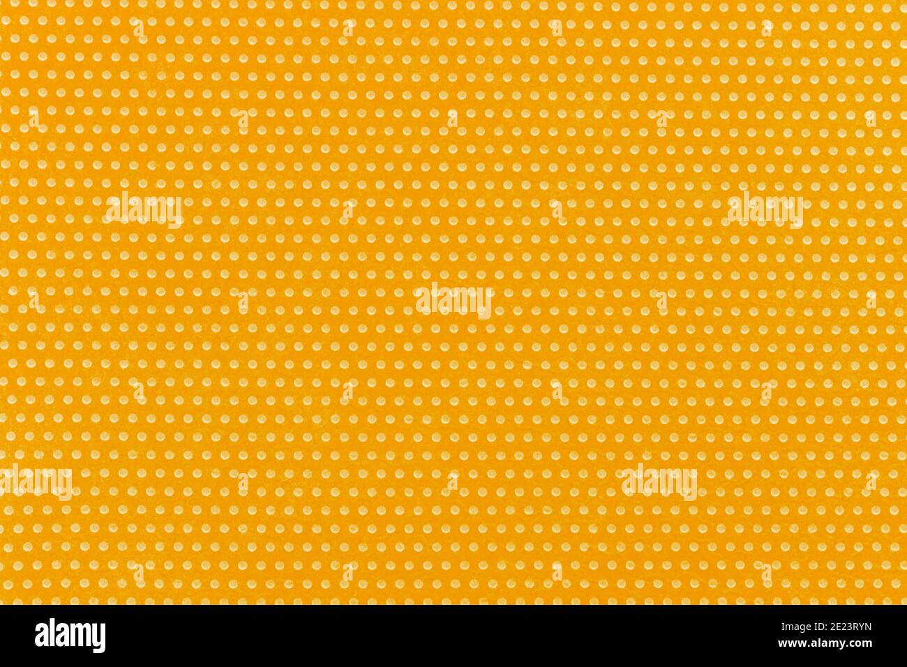 Textile homogeneous background color yellow in white fine polka dots, horizontal pattern. View from above. Emotionally warm sunny mustard sandy saturated. Stock Photo