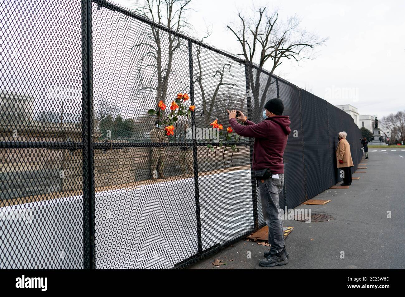 Washington, USA. 12th Jan, 2021. People take photos of the U.S. Capitol Building across a barrier fence in Washington, DC, the United States, Jan. 11, 2021. TO GO WITH 'U.S. House Democrats unveil article of impeachment against Trump'. Credit: Liu Jie/Xinhua/Alamy Live News Stock Photo