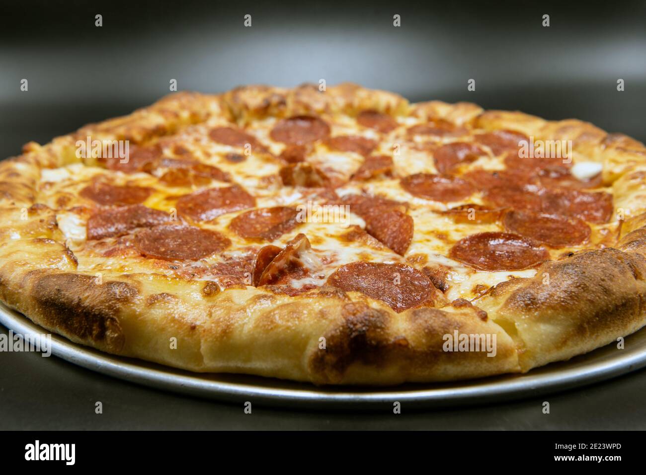 Stuffed crust pizza covered with pepperoni and melted cheese for a very hearty meal. Stock Photo