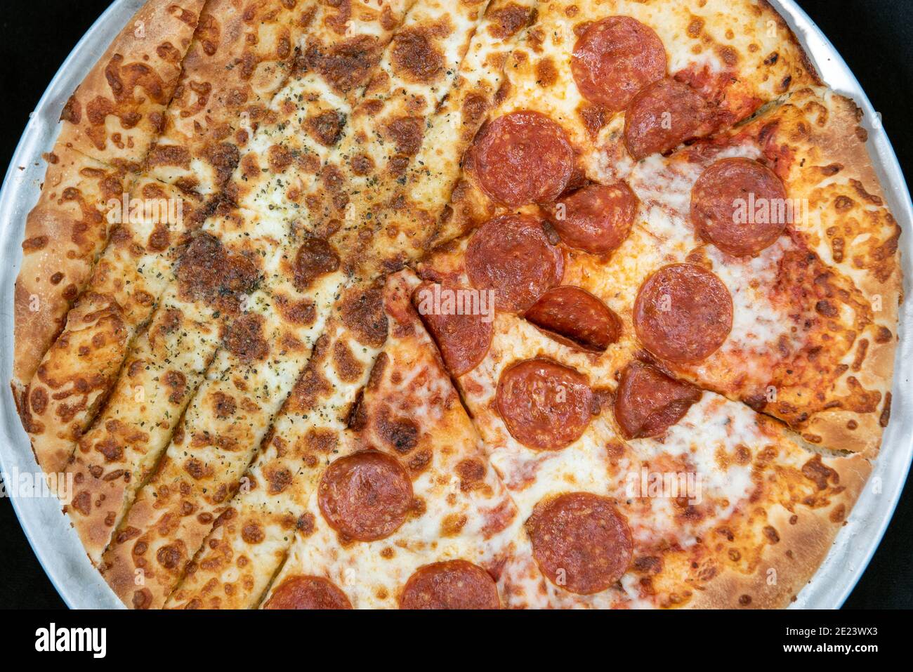 Overhead view of unique pizza is half bread sticks and half pepperoni