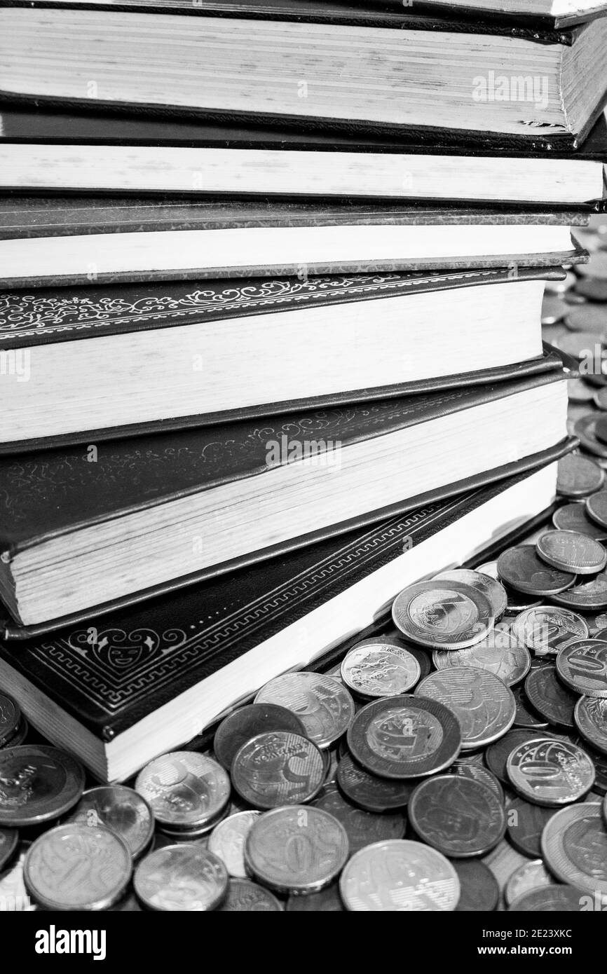 Pile of classics books surrounded with coins [Black and White version] Stock Photo
