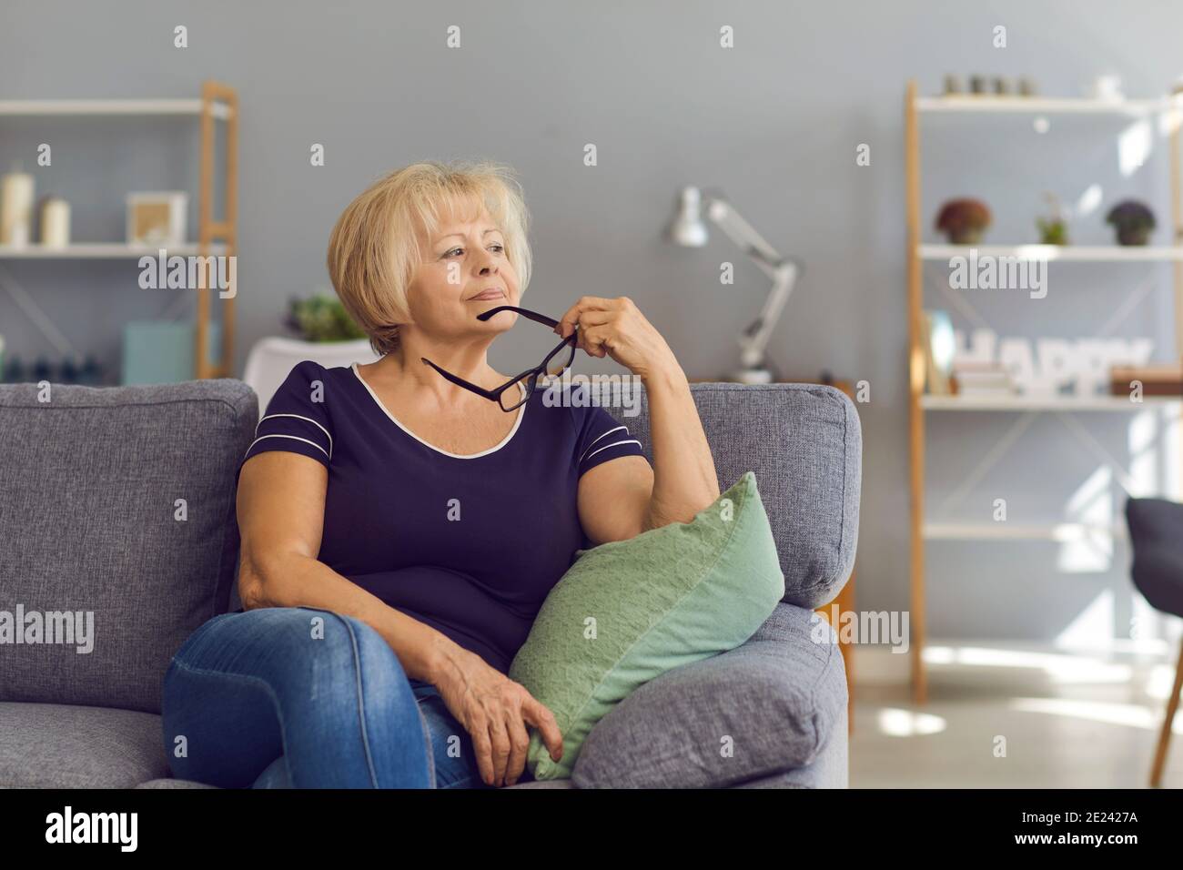 Mature woman sitting on sofa hi-res stock photography and images - Alamy