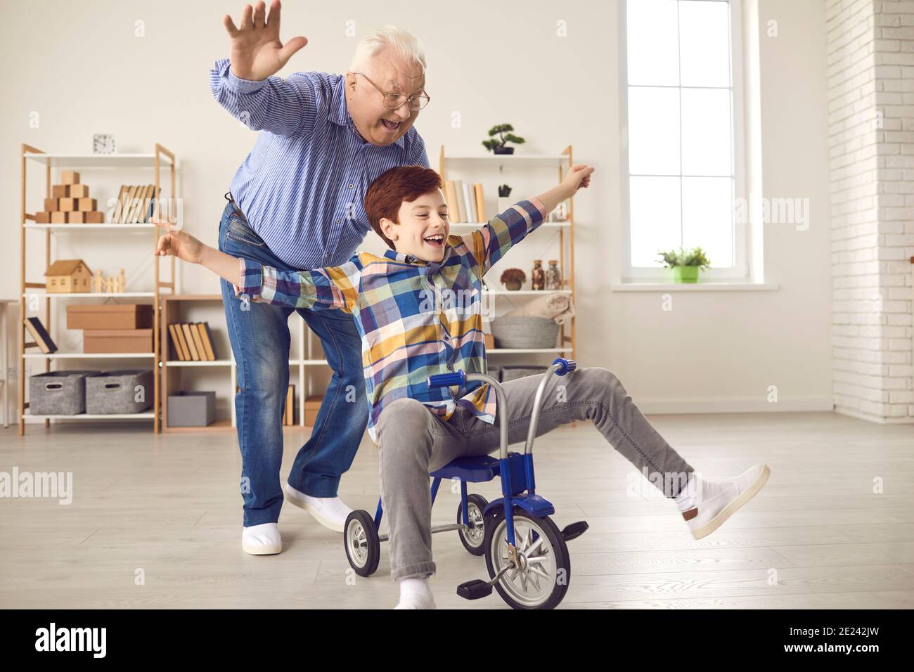 Happy energetic grandad and grandson playing childish games and having fun at home Stock Photo