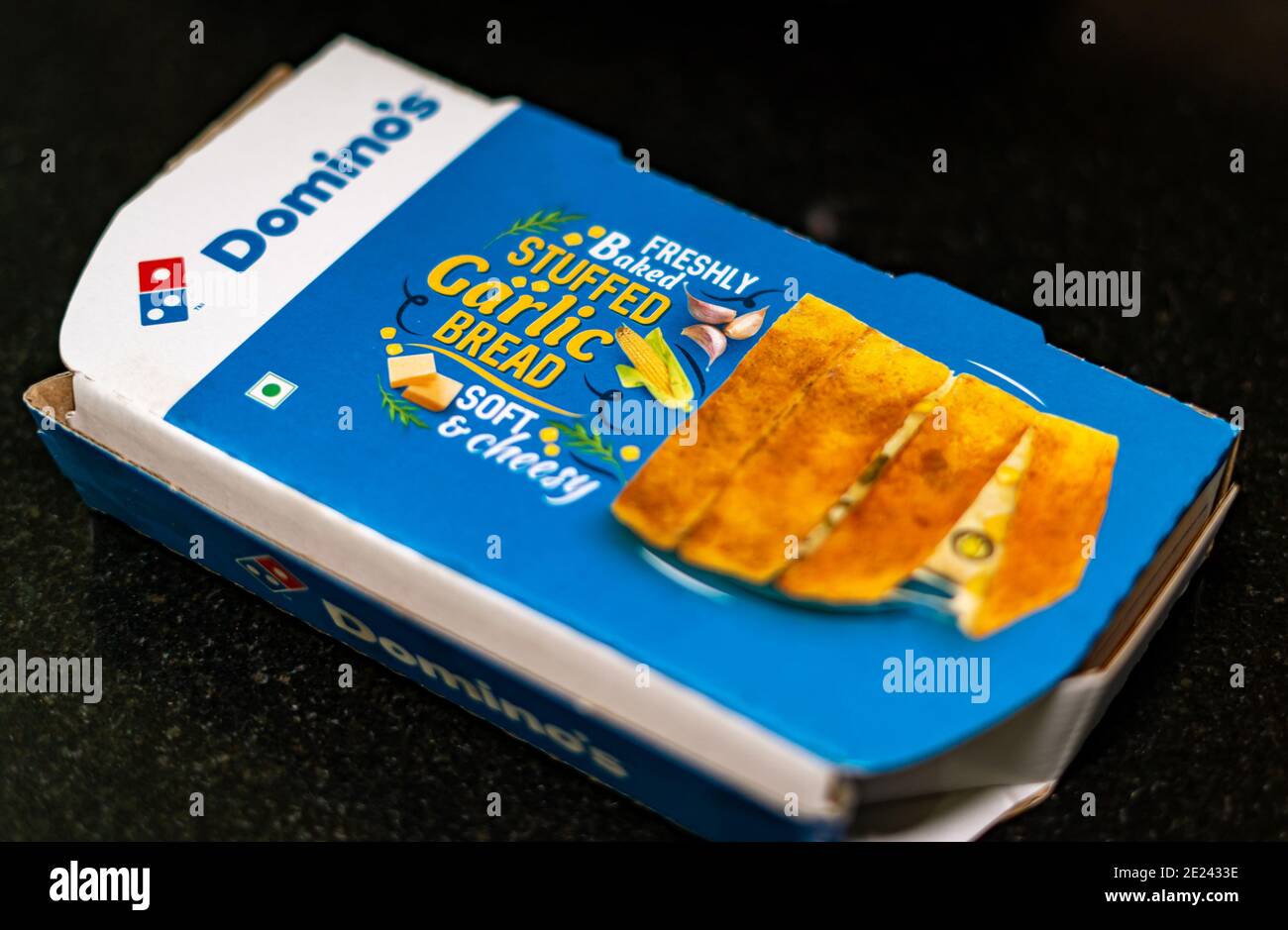 Takeout box of Domino's Stuffed Garlic Bread on a black granite background Stock Photo