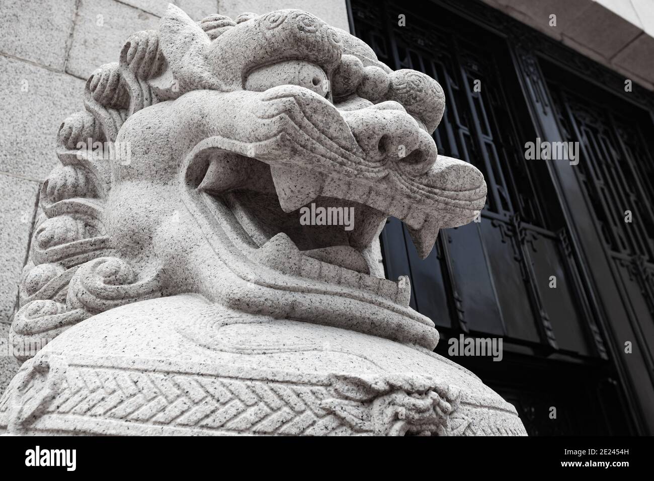 Head of a white stone Chinese lion statue at the entrance to Buddhist temple Stock Photo