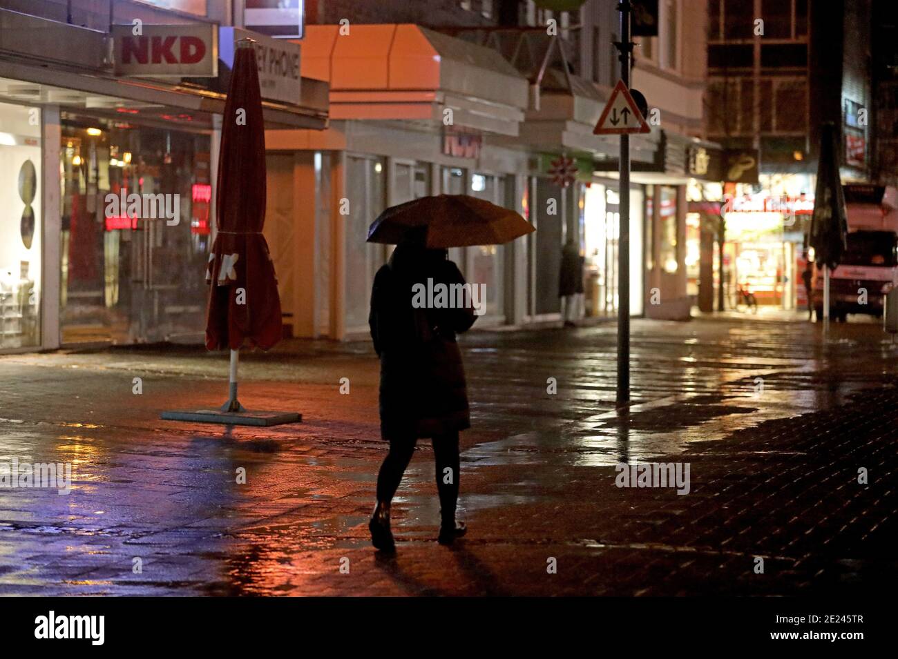 Gummersbach, Germany. 12th Jan, 2021. A woman walks through the pedestrian zone in the morning. The 15-kilometer-rule for extreme Corona hotspots is also valid in North Rhine-Westphalia since Tuesday. The regulation affects the districts of Höxter, Minden-Lübbecke, Recklinghausen and the Oberbergischer Kreis. (To dpa/lnw: '15-kilometer rule now for four counties in NRW: With exceptions') Credit: Oliver Berg/dpa/Alamy Live News Stock Photo