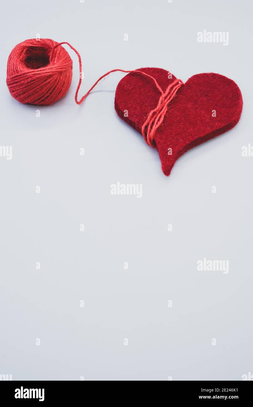 Two Threads Wrapped Around Vertical shot of a bright red yarn with threads wrapped around a red ...