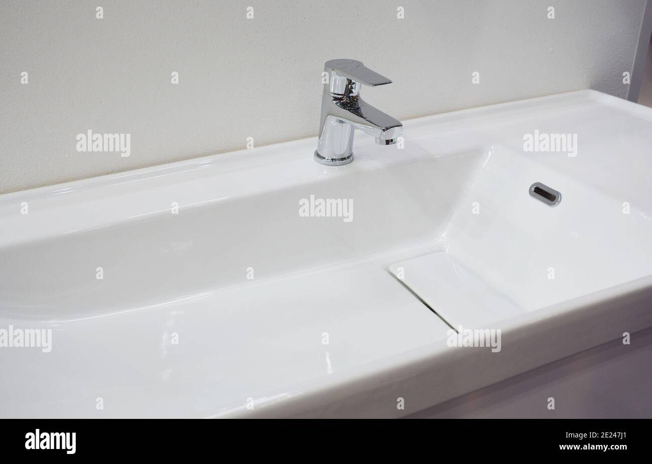 A closeup of a white porcelain ceramic shallow rectangle wall mounted