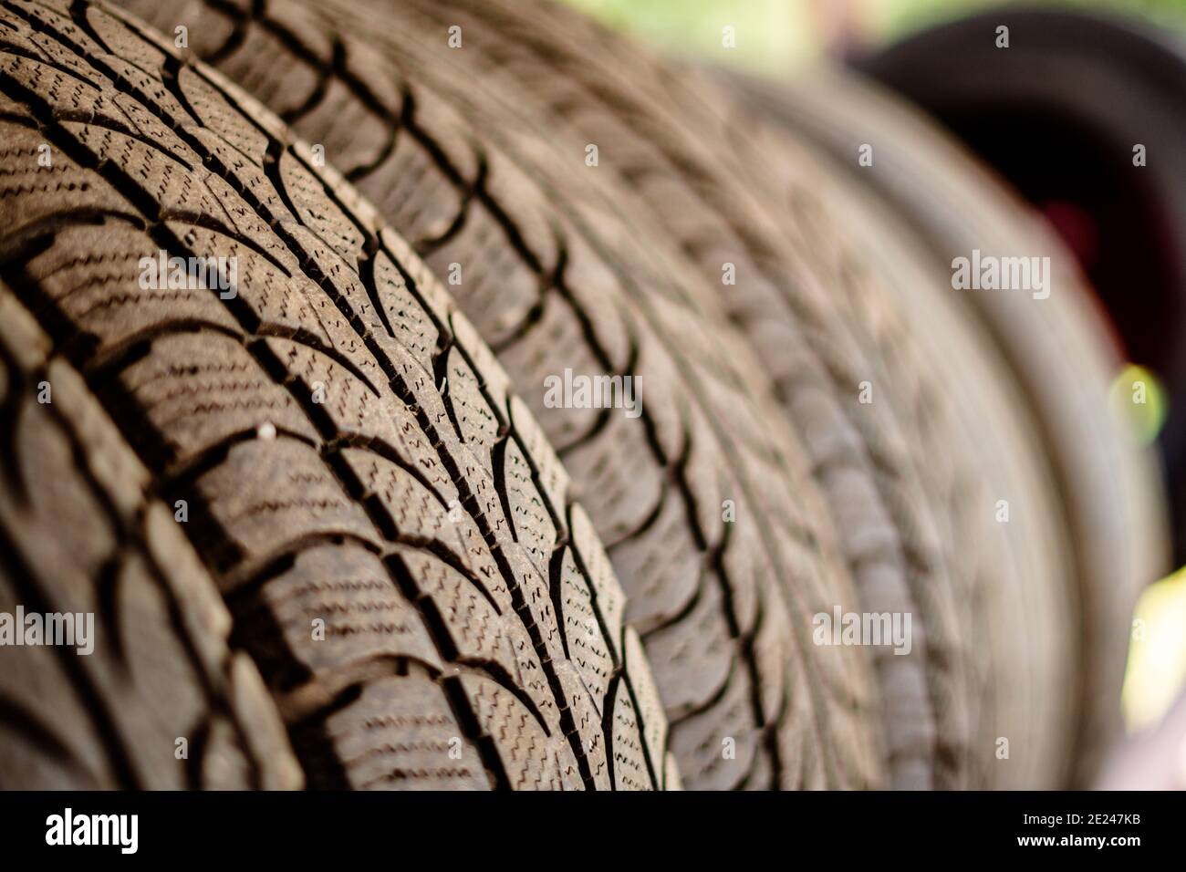 Old car tires stand on a metal rack in the installation workshop Stock