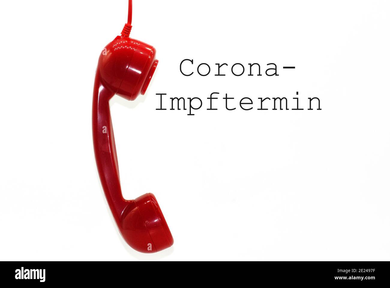 Red phone with a 'Corona-Impftermin - Corona vaccination appointment' text on a white background Stock Photo
