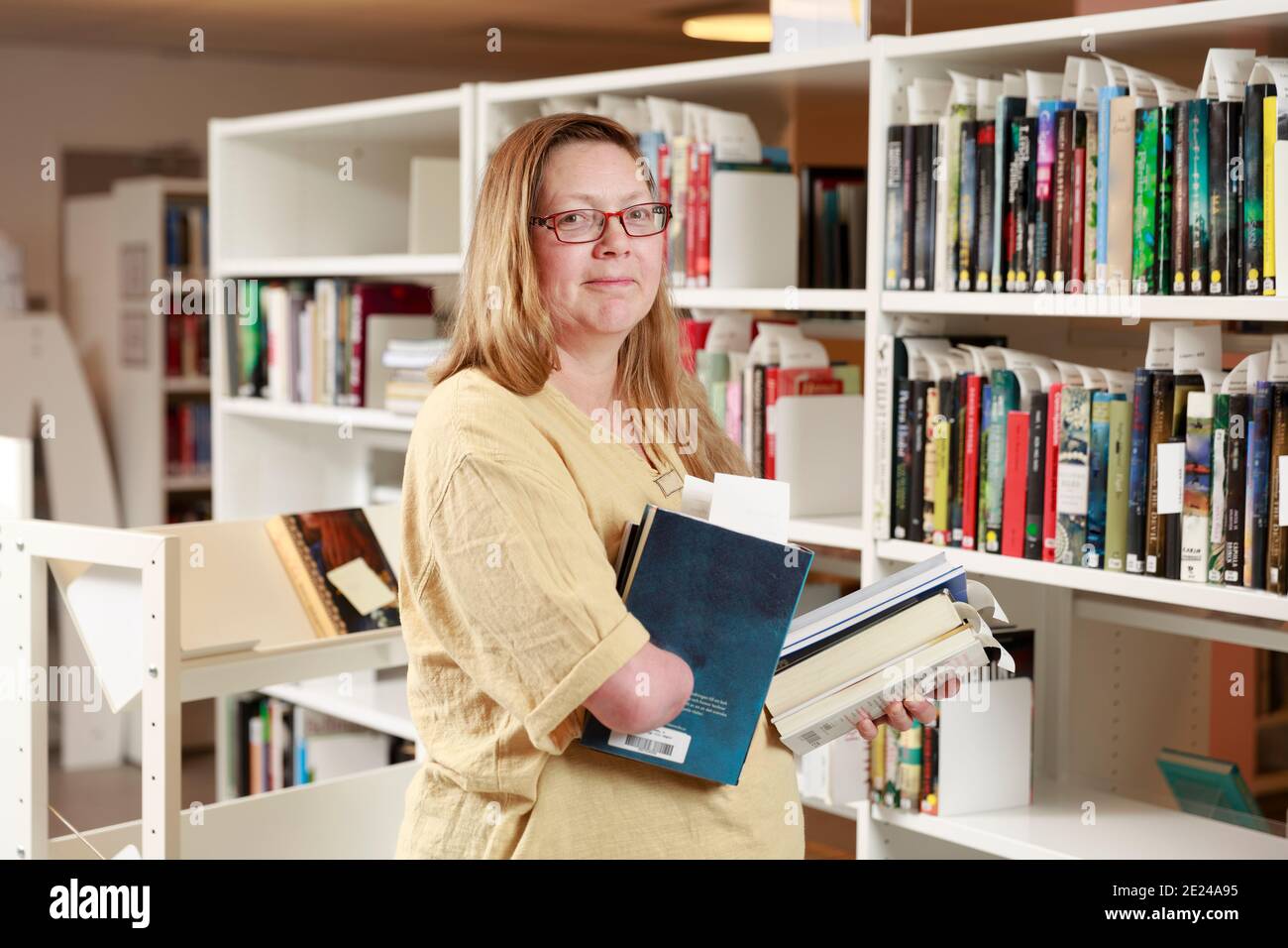 Librarian placing books on shelf Stock Photo