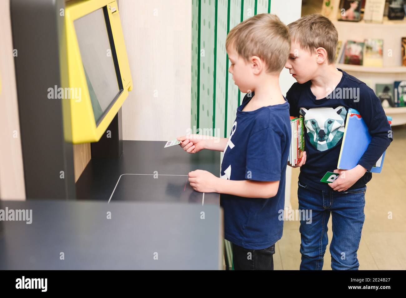 Boys using self service point in library Stock Photo