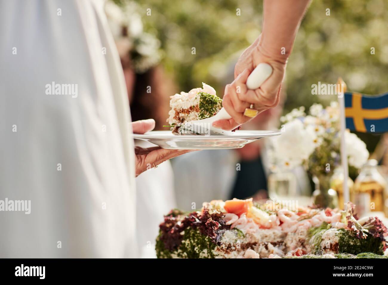 Close-up of woman putting cake on plate Stock Photo