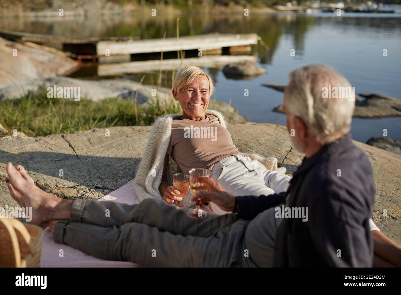Smiling couple having picnic at lake Stock Photo